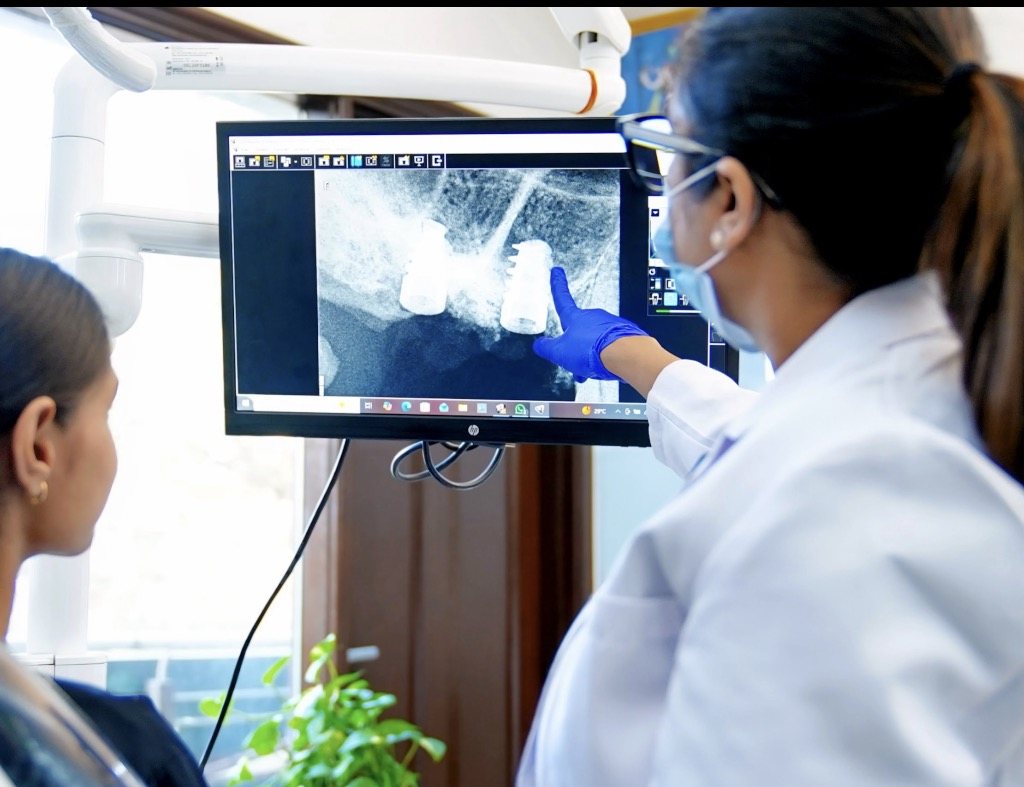 Dentist explaining a dental implant X-ray to a patient at Ark Dental Global